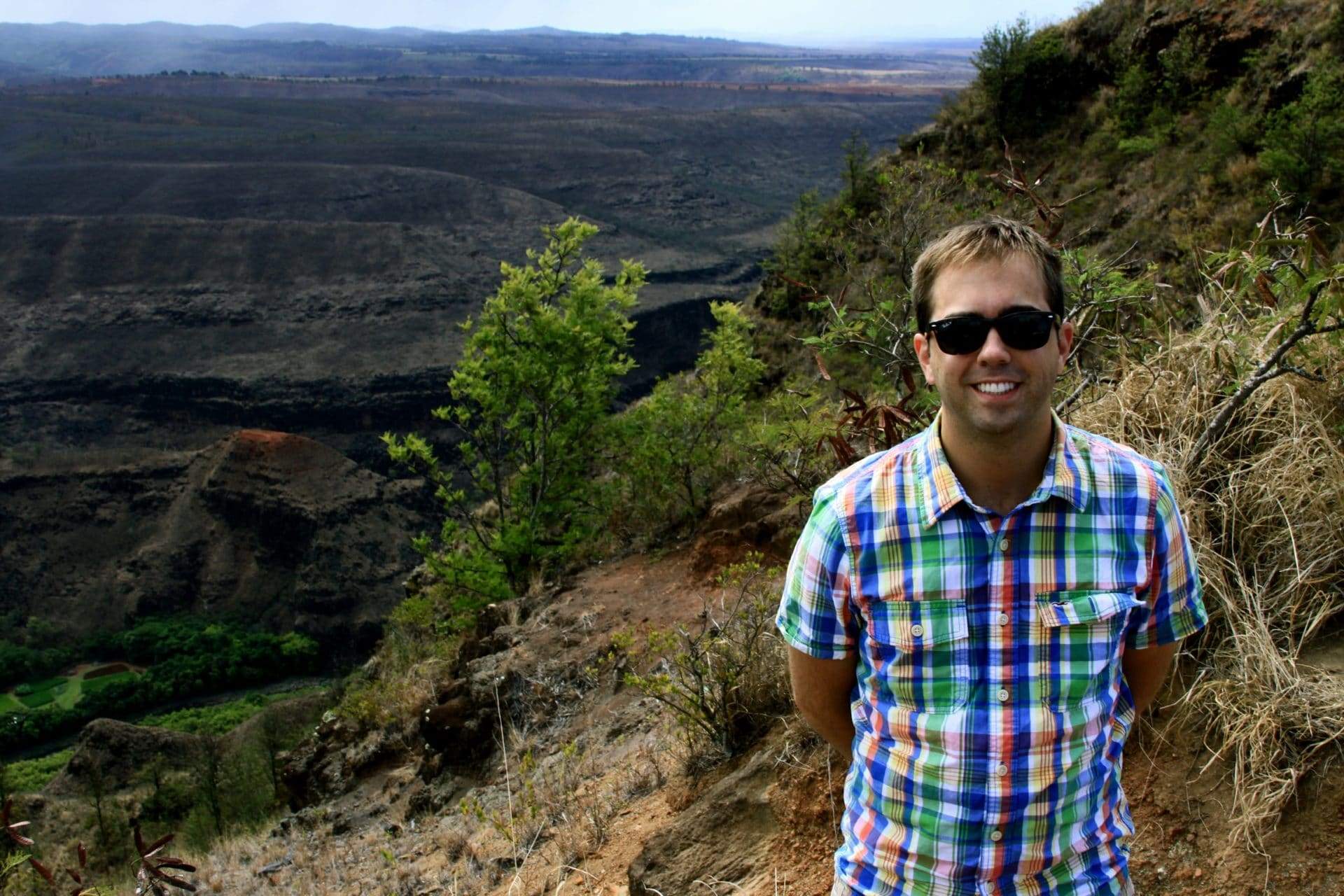 A man posing on a hiking trail, exemplifying one perk of a work from home travel agent job