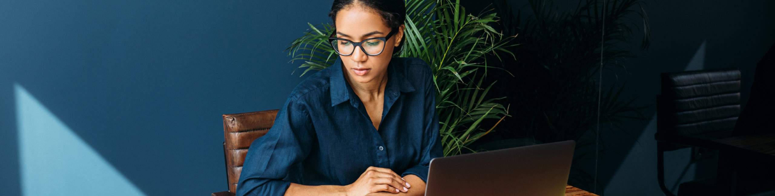 A woman working at a table in a sunlit room - discover work-from-home travel agent jobs