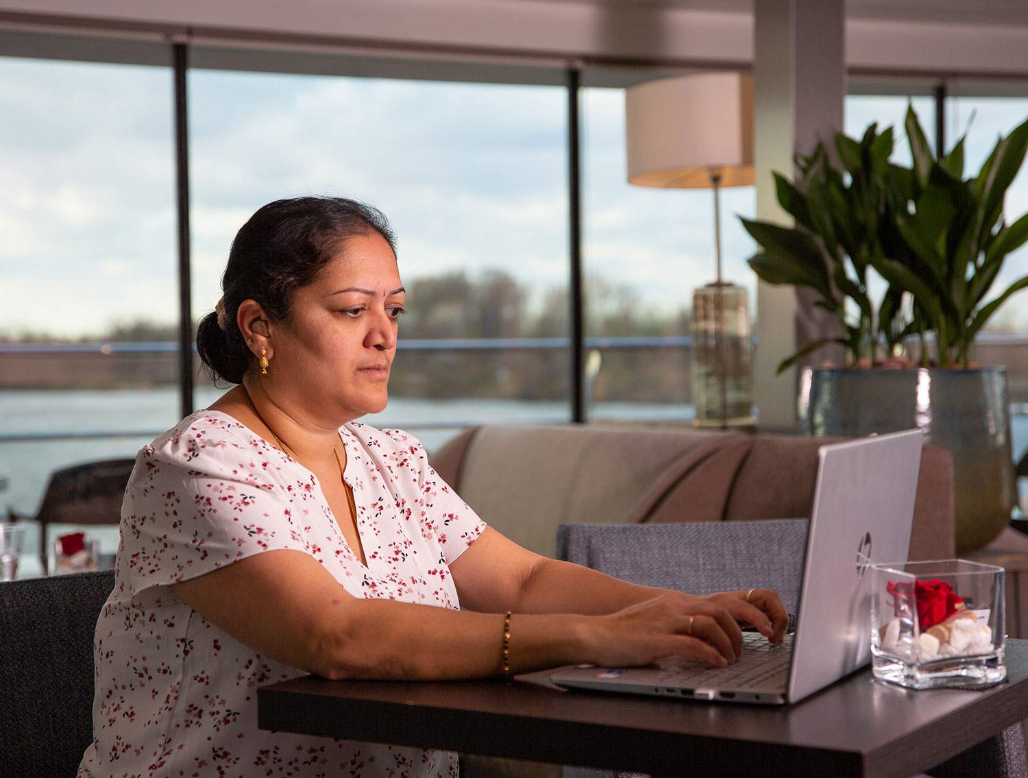 woman sitting at desk on a laptop - how to make money remotely while traveling