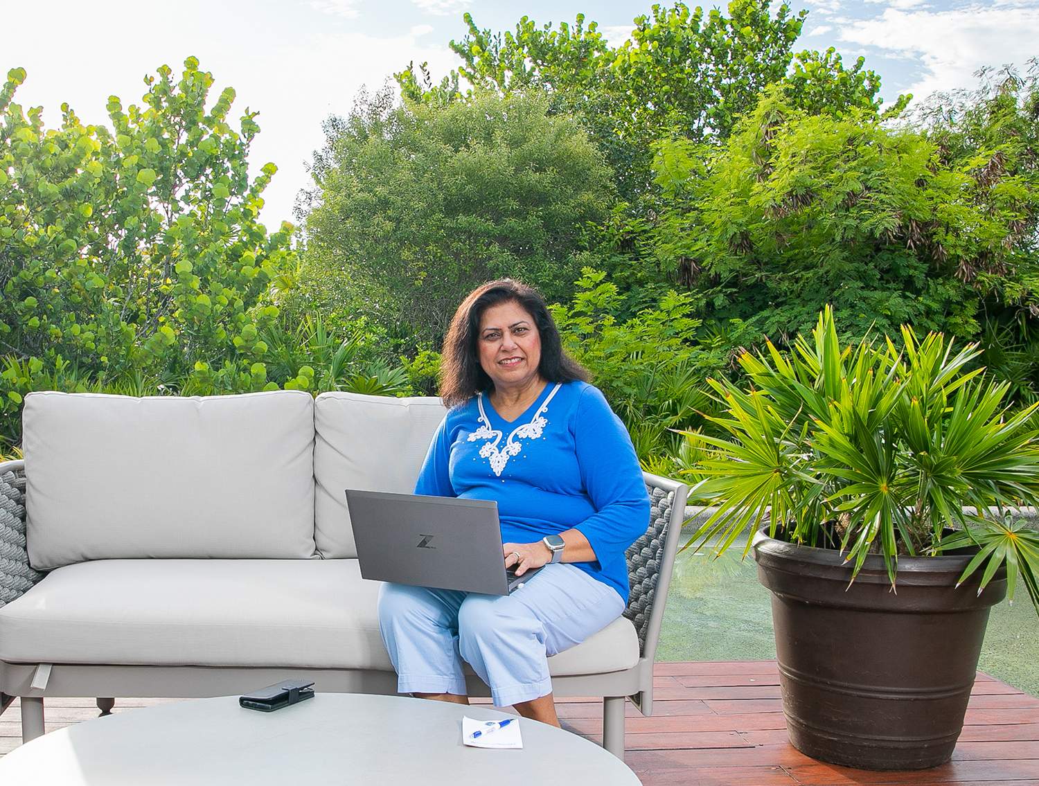 Dream Vacation Advisor on outdoor couch with laptop