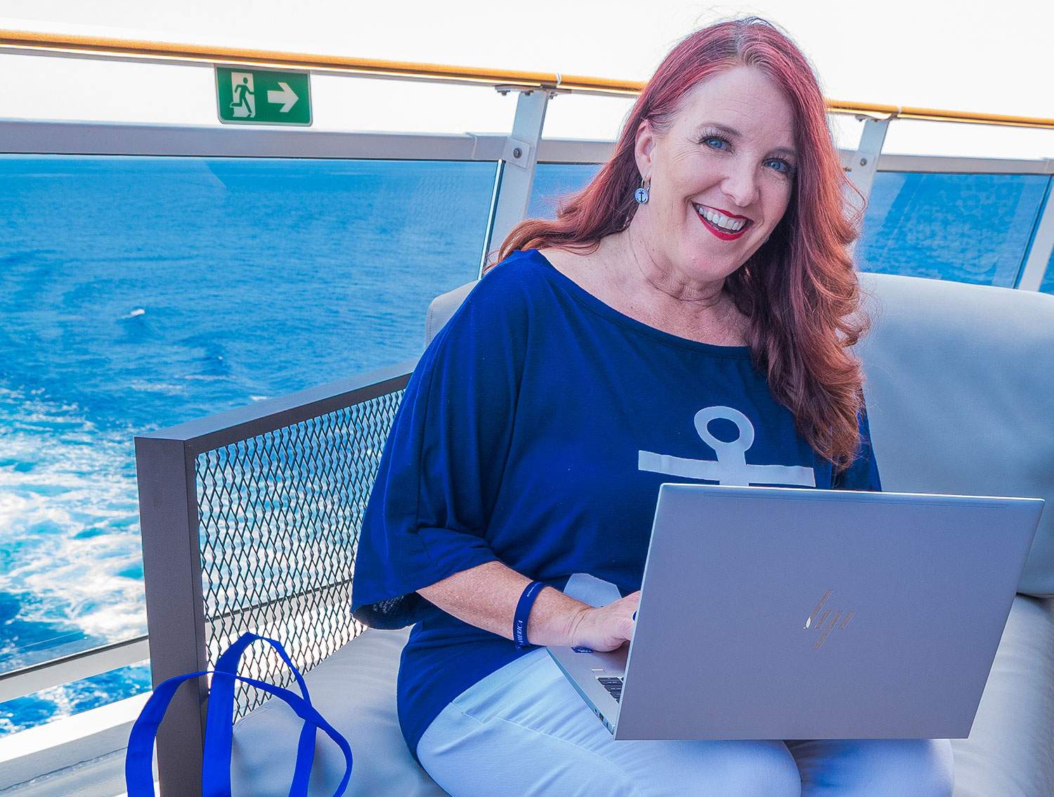 woman on laptop by ship railing