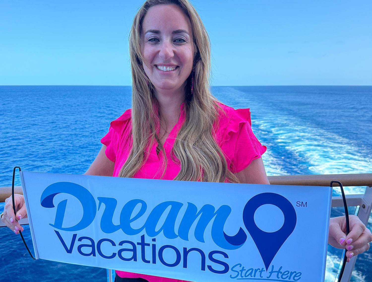 woman on boat with a Dream Vacations sign