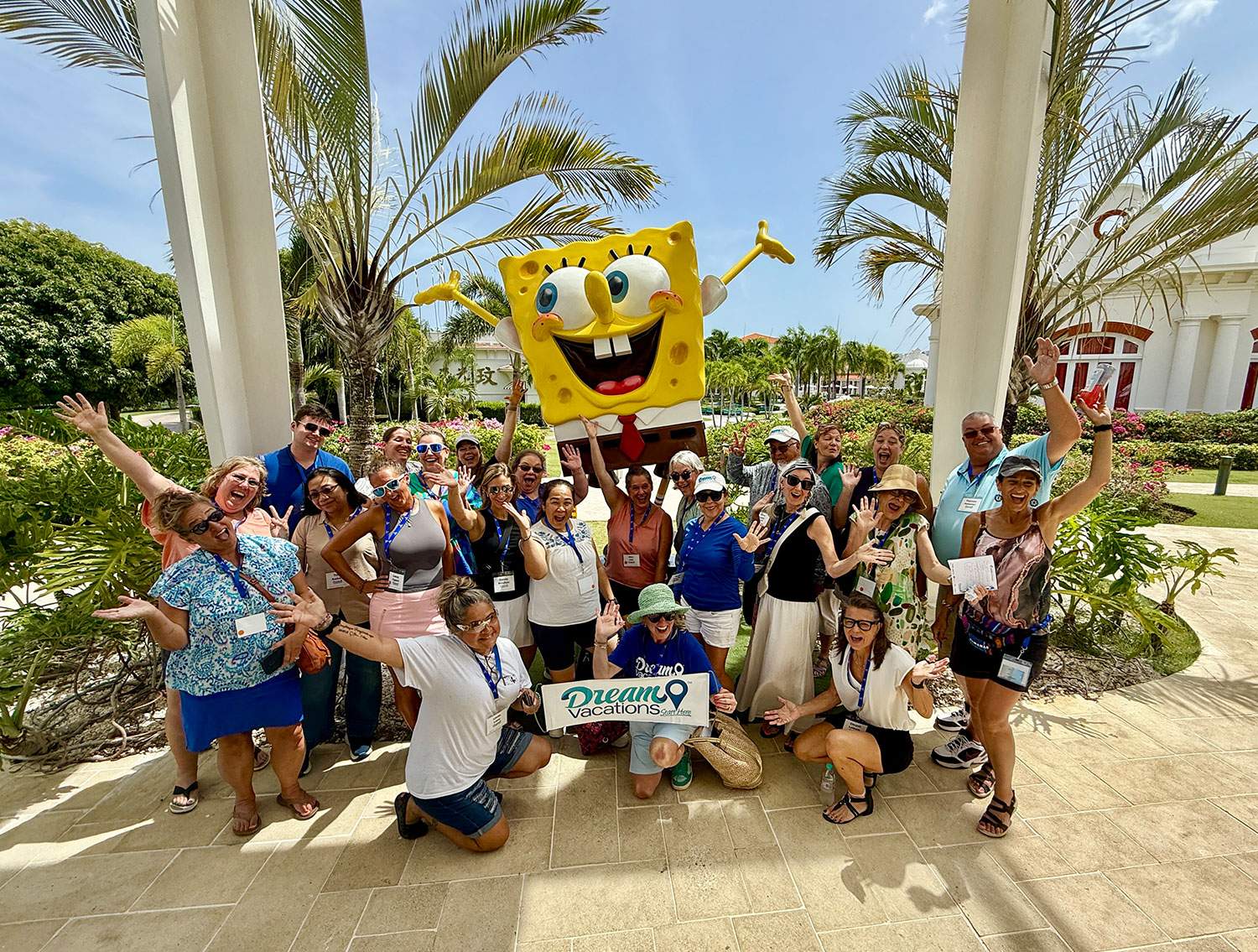 A group of people smiling and posing with a large SpongeBob SquarePants character at a fun event.
