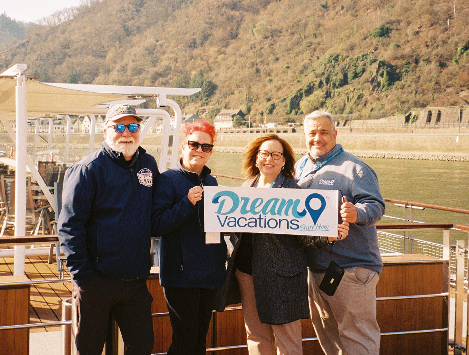 A group of people holding a Dream Vacations sign.